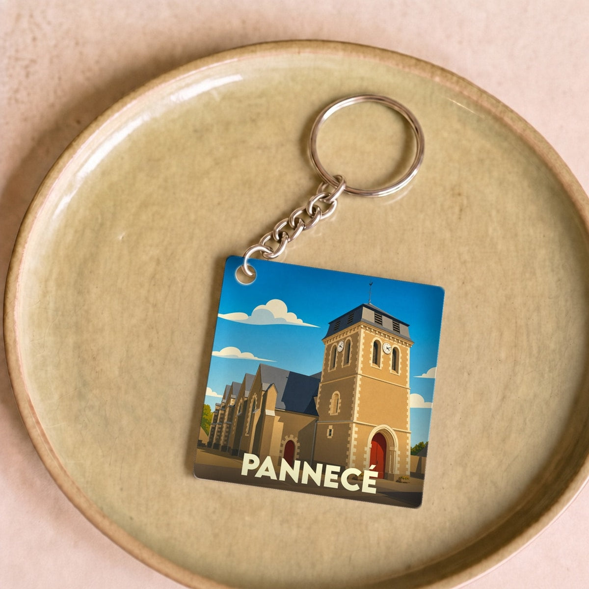 Porte-clés souvenir de la ville de Pannecé avec une illustration stylisée de son église.