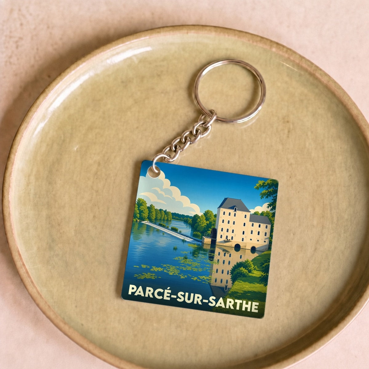Porte-clés souvenir de la ville de Parcé-sur-Sarthe avec une illustration stylisée.
