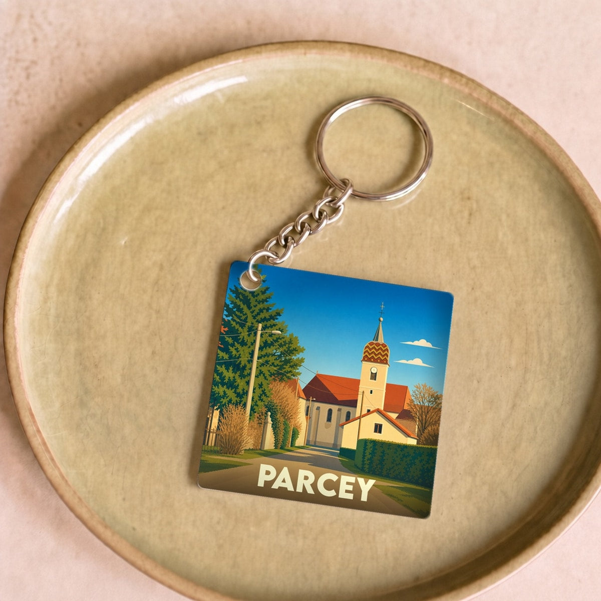 Porte-clés souvenir de la ville de Parcey avec une illustration stylisée d'une église et son clocher.