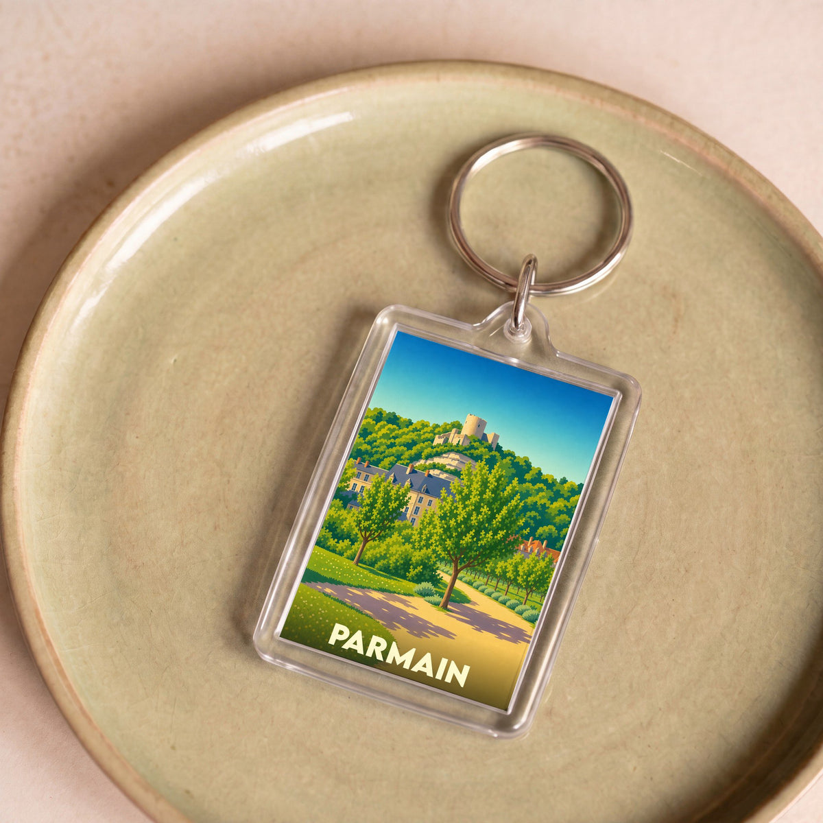 Porte-clés souvenir de la ville de Parmain avec une illustration stylisée.