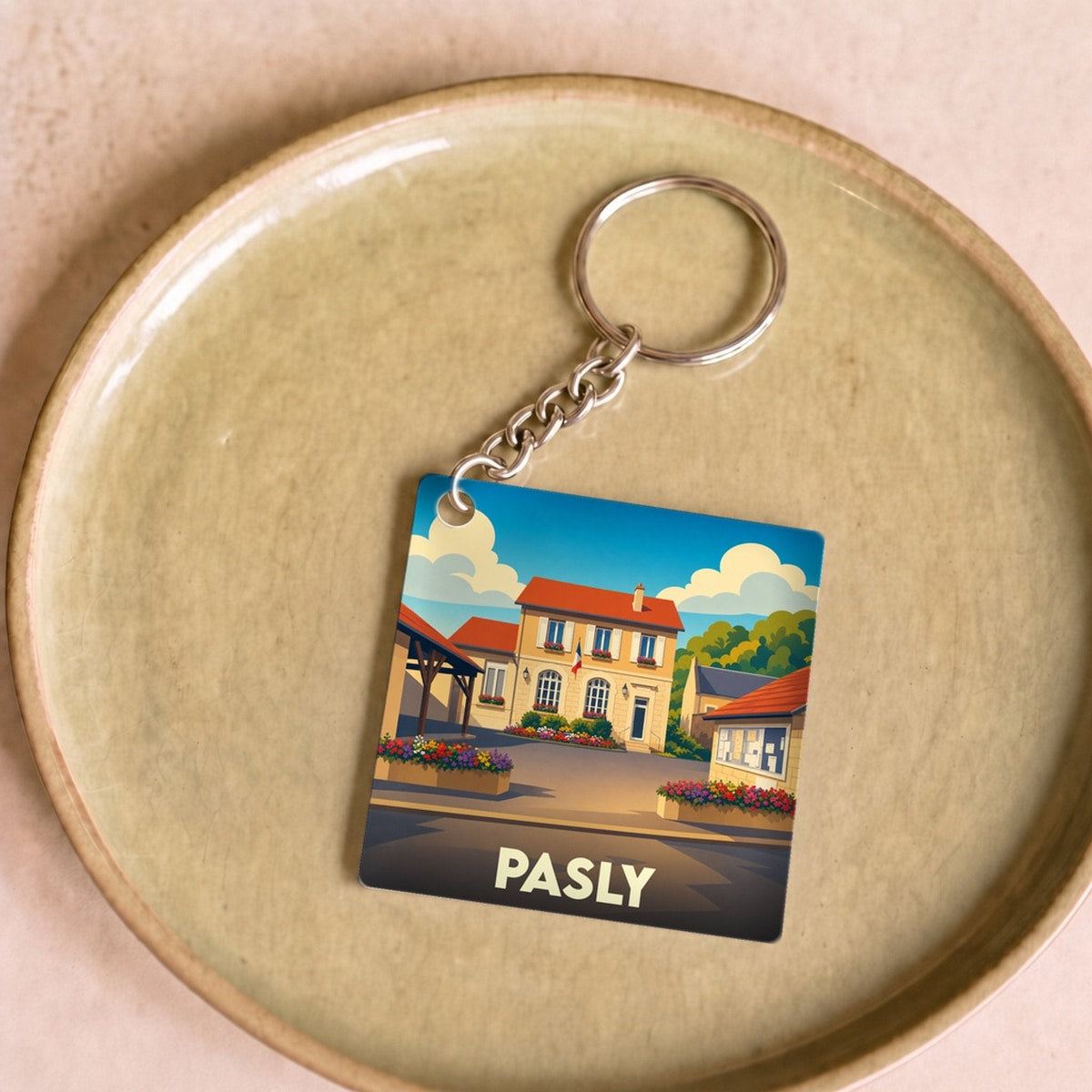 Porte-clés souvenir de la ville de Pasly avec une illustration stylisée.