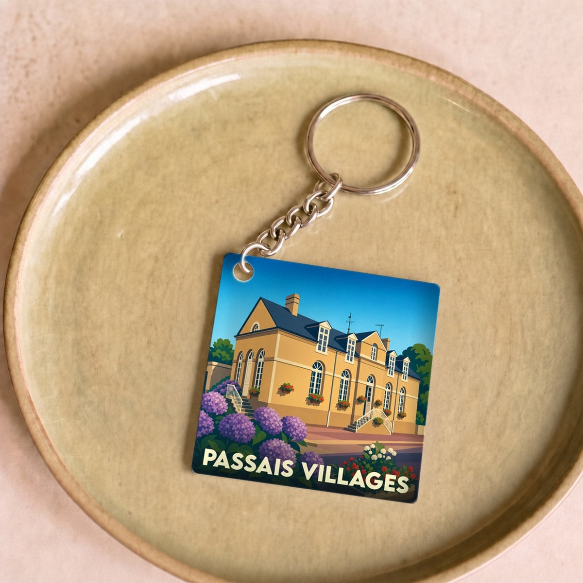 Porte-clés souvenir de la ville de Passais Villages avec une illustration stylisée.