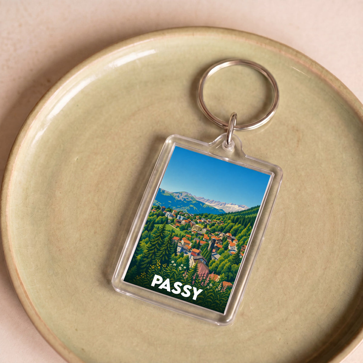 Porte-clés souvenir de la ville de Passy illustré d'un paysage de montagne stylisé.