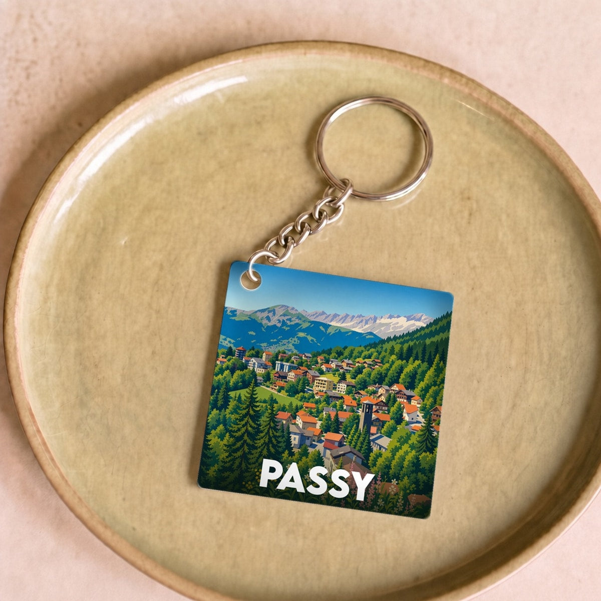 Porte-clés souvenir de la ville de Passy illustré d'un paysage de montagne stylisé.