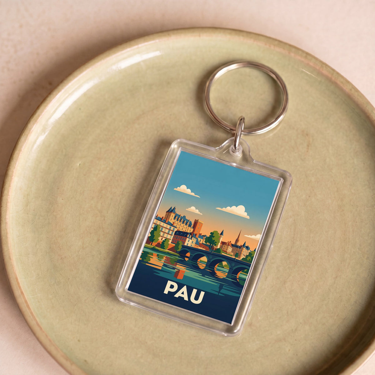 Porte-clés souvenir de la ville de Pau avec une illustration stylisée.