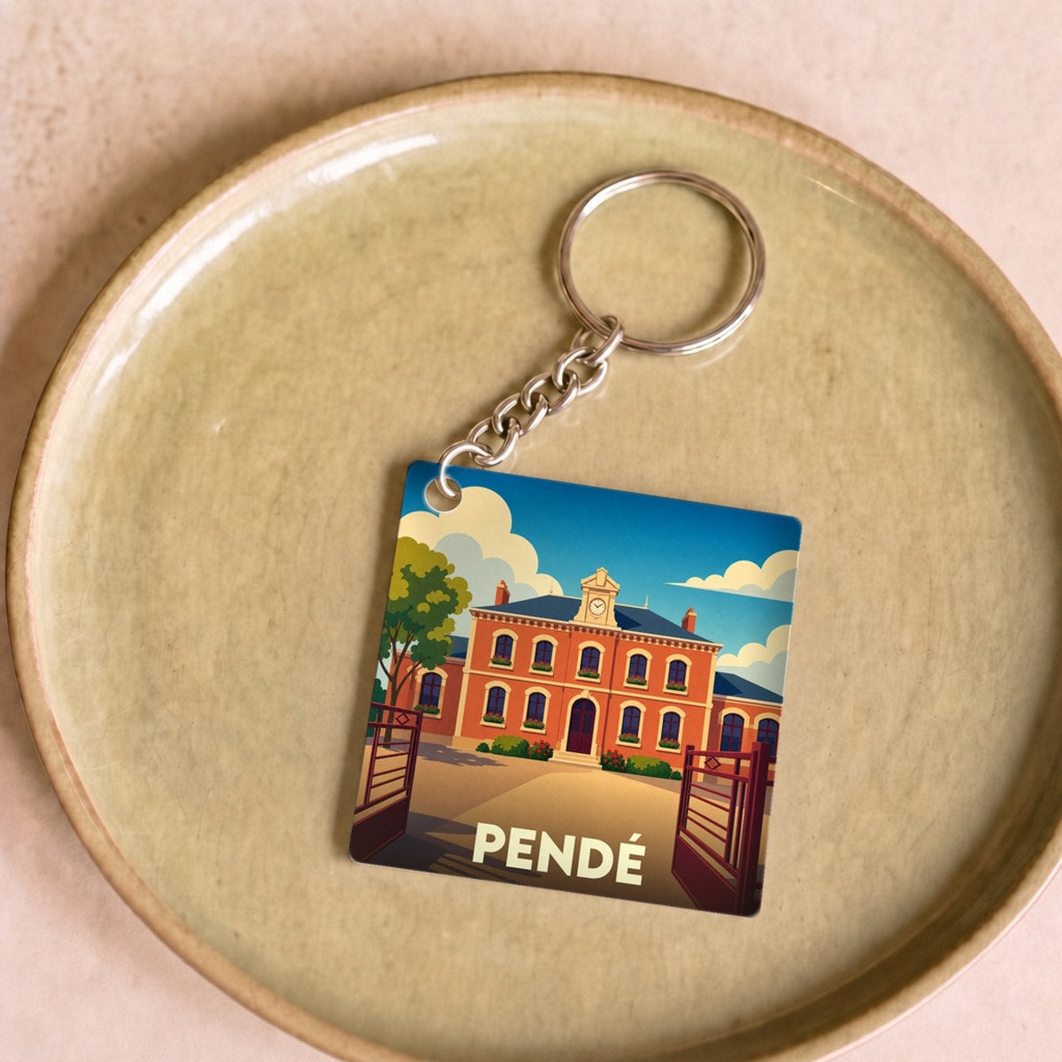 Porte-clés souvenir de la ville de Pendé avec une illustration stylisée.