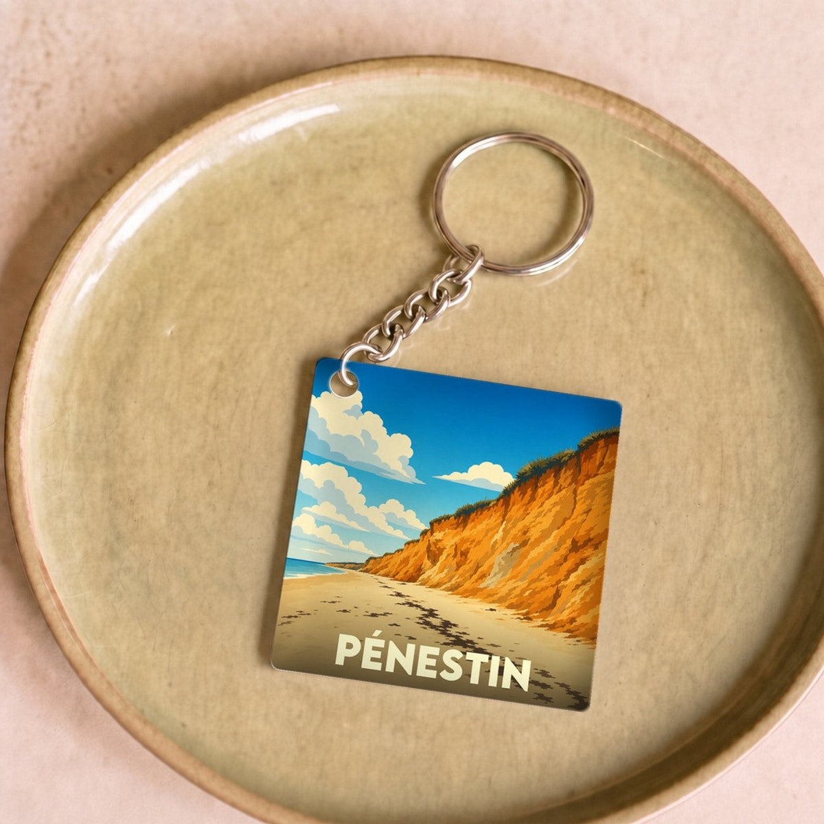 Porte-clés souvenir de la ville de Pénestin avec une illustration stylisée de ses falaises.