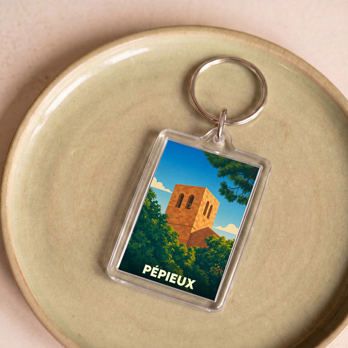 Porte-clés souvenir de la ville de Pépieux avec une illustration stylisée.