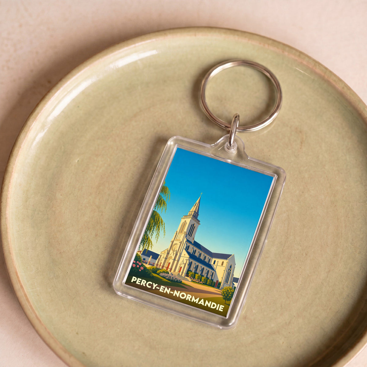 Porte-clés souvenir de la ville de Percy-en-Normandie avec une illustration stylisée de son église.
