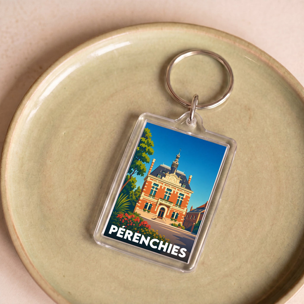 Porte-clés souvenir de la ville de Pérenchies avec une illustration stylisée.