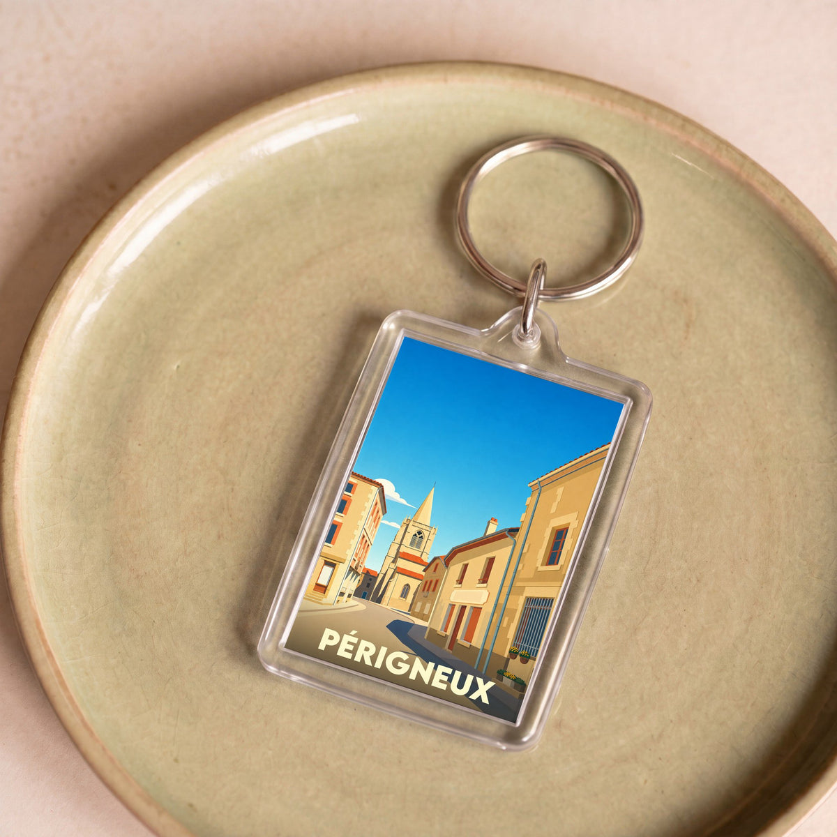 Porte-clés souvenir de la ville de Périgneux avec une illustration stylisée.