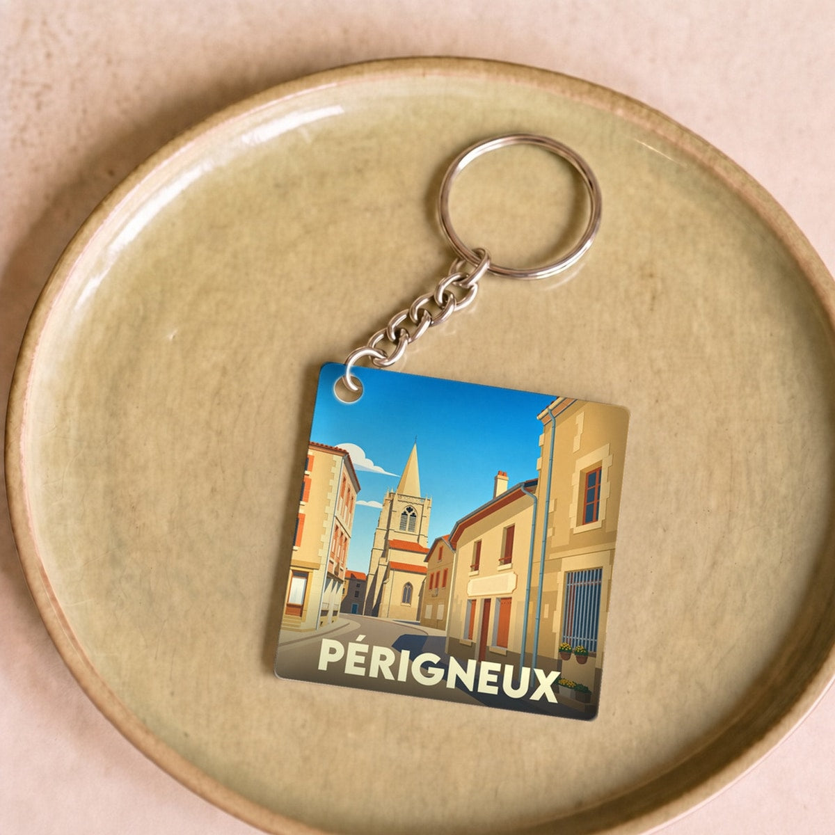 Porte-clés souvenir de la ville de Périgneux avec une illustration stylisée.