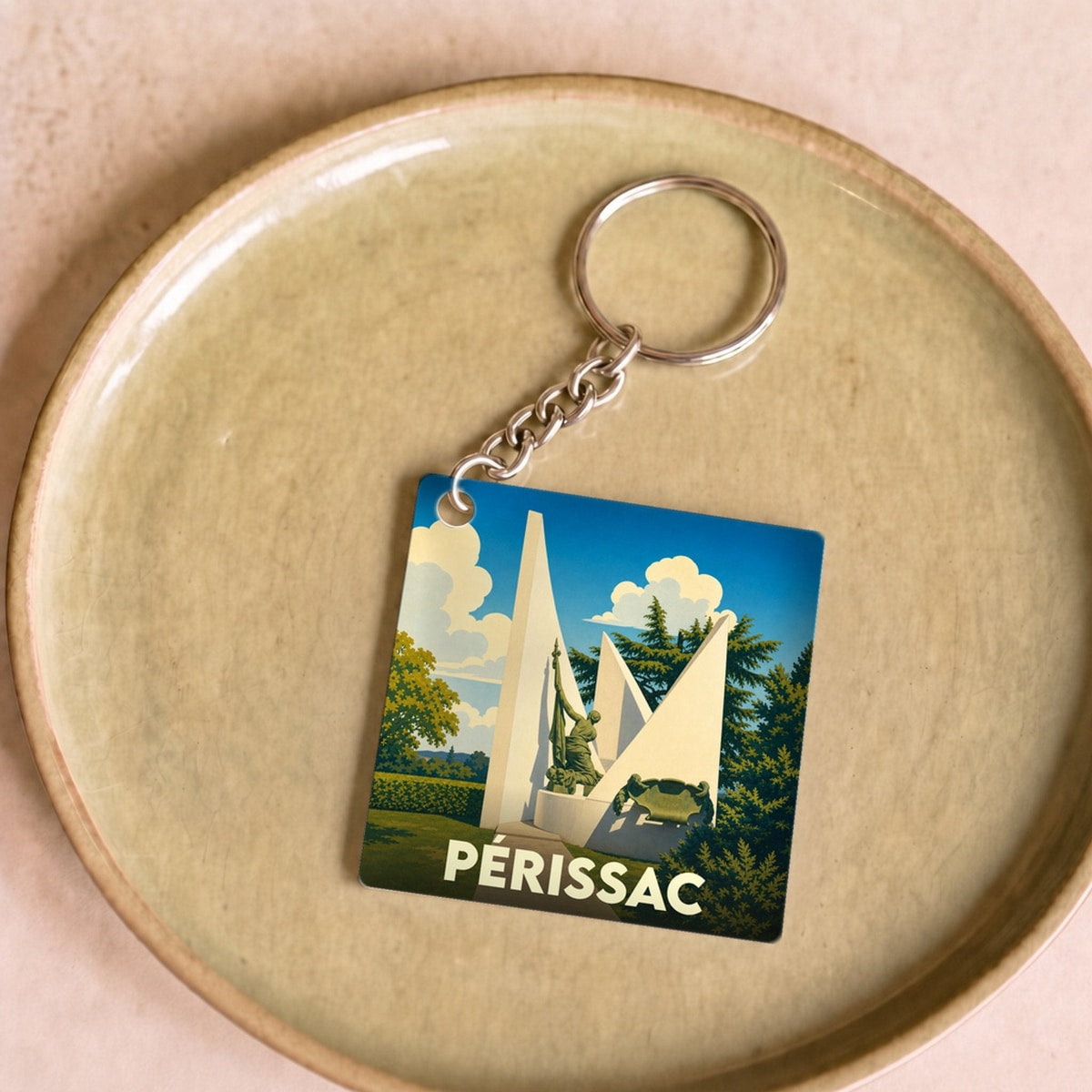 Porte-clés souvenir de la ville de Périssac avec une illustration stylisée de son monument.
