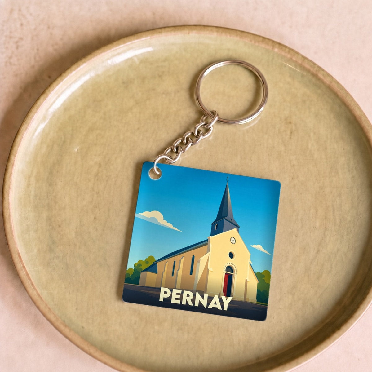 Porte-clés souvenir de la ville de Pernay avec une illustration stylisée de son église.