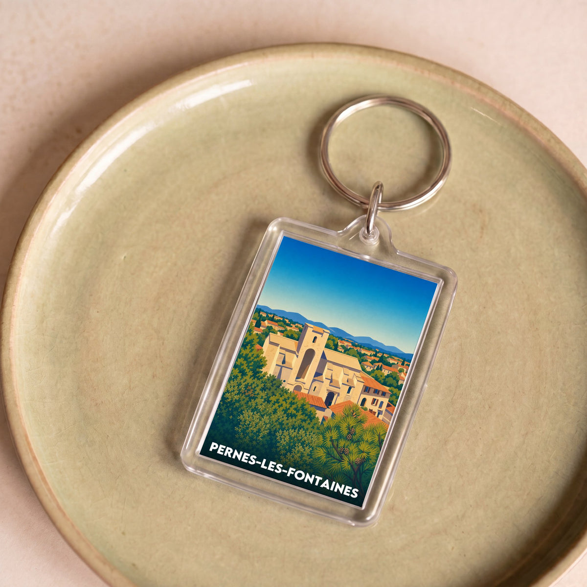 Porte-clés souvenir de la ville de Pernes-les-Fontaines avec une illustration stylisée.