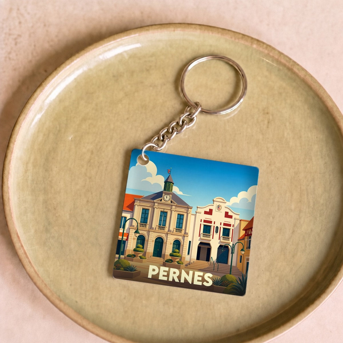 Porte-clés souvenir de la ville de Pernes avec une illustration stylisée.