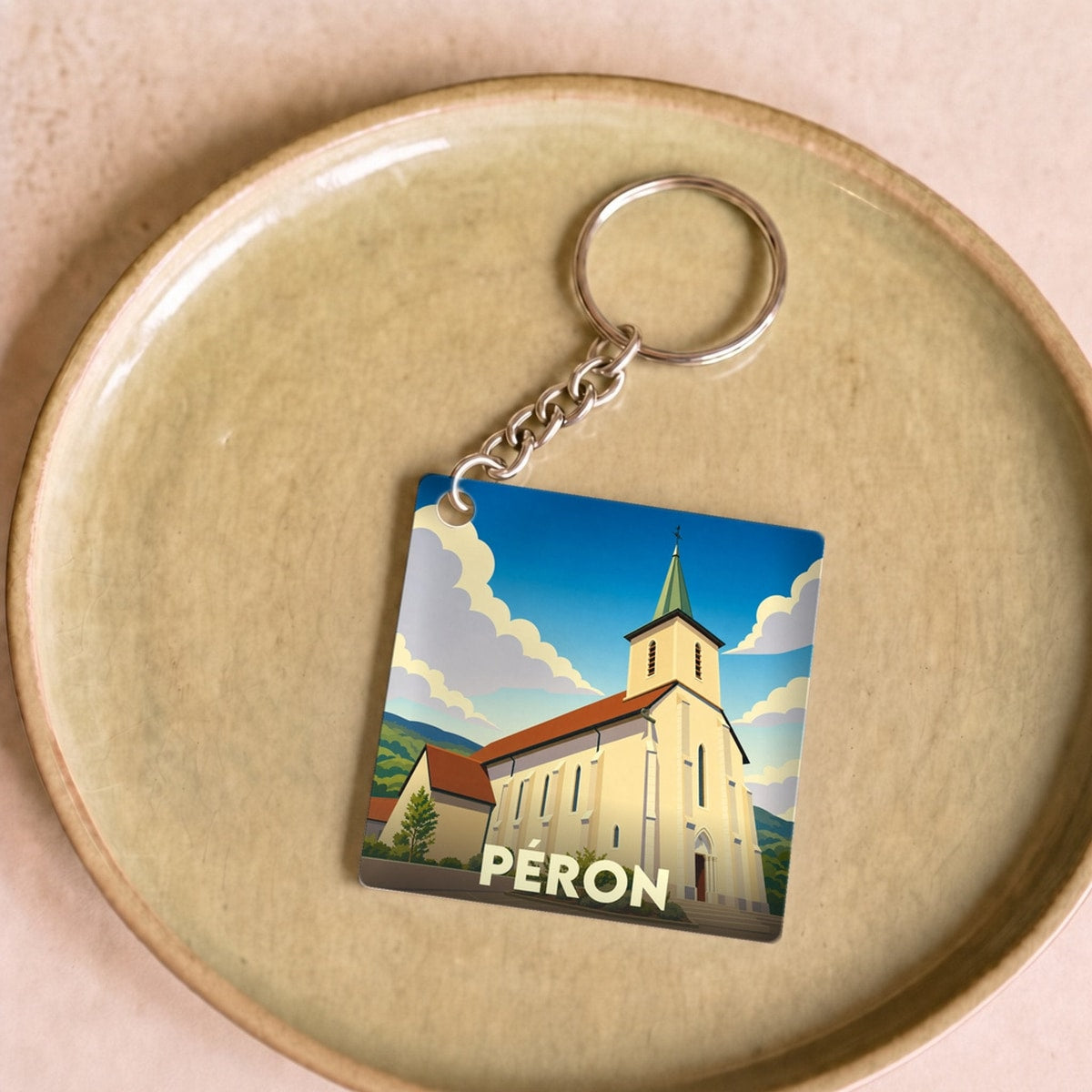 Porte-clés souvenir de la ville de Péron avec une illustration stylisée de son église.
