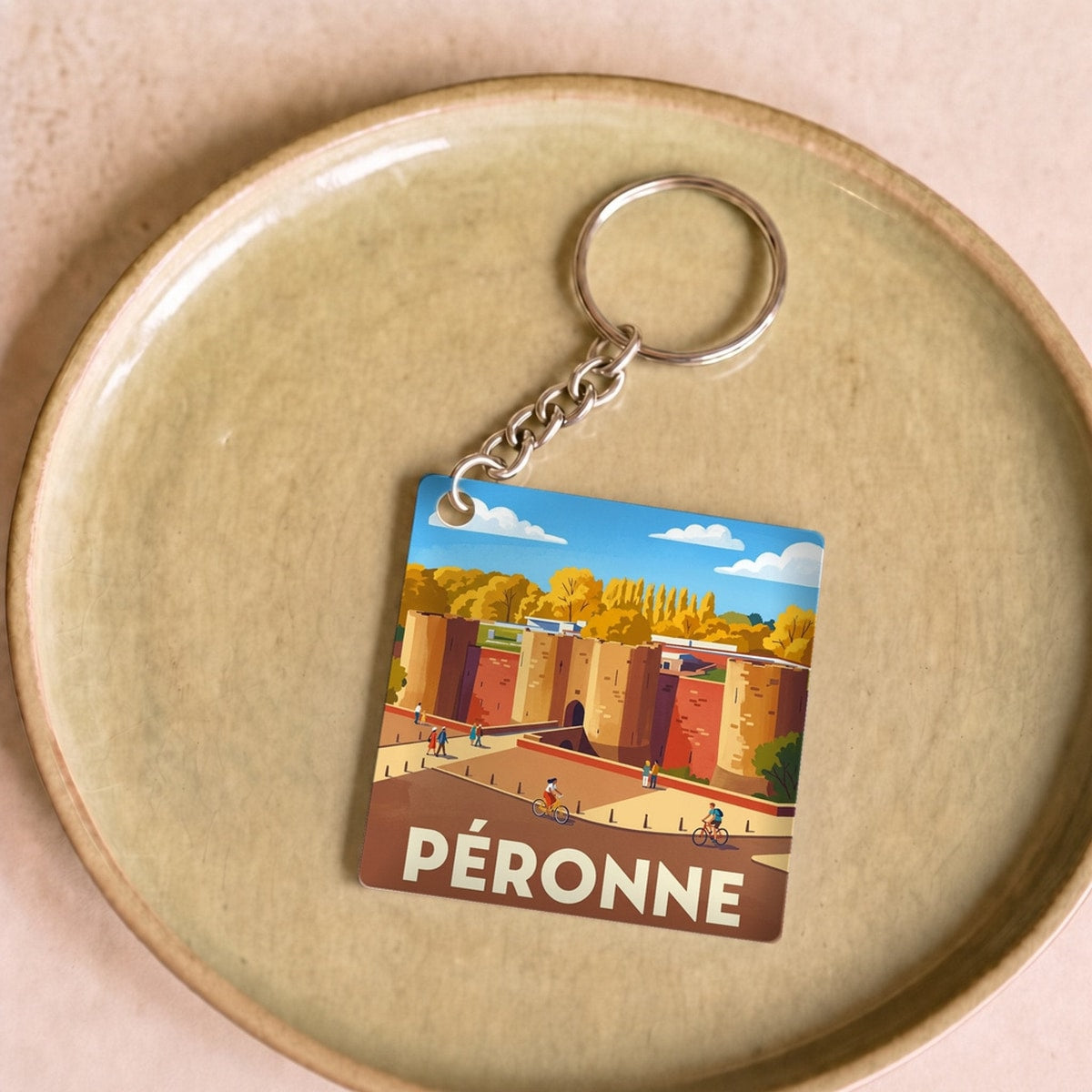 Porte-clés souvenir de la ville de Péronne avec une illustration stylisée.