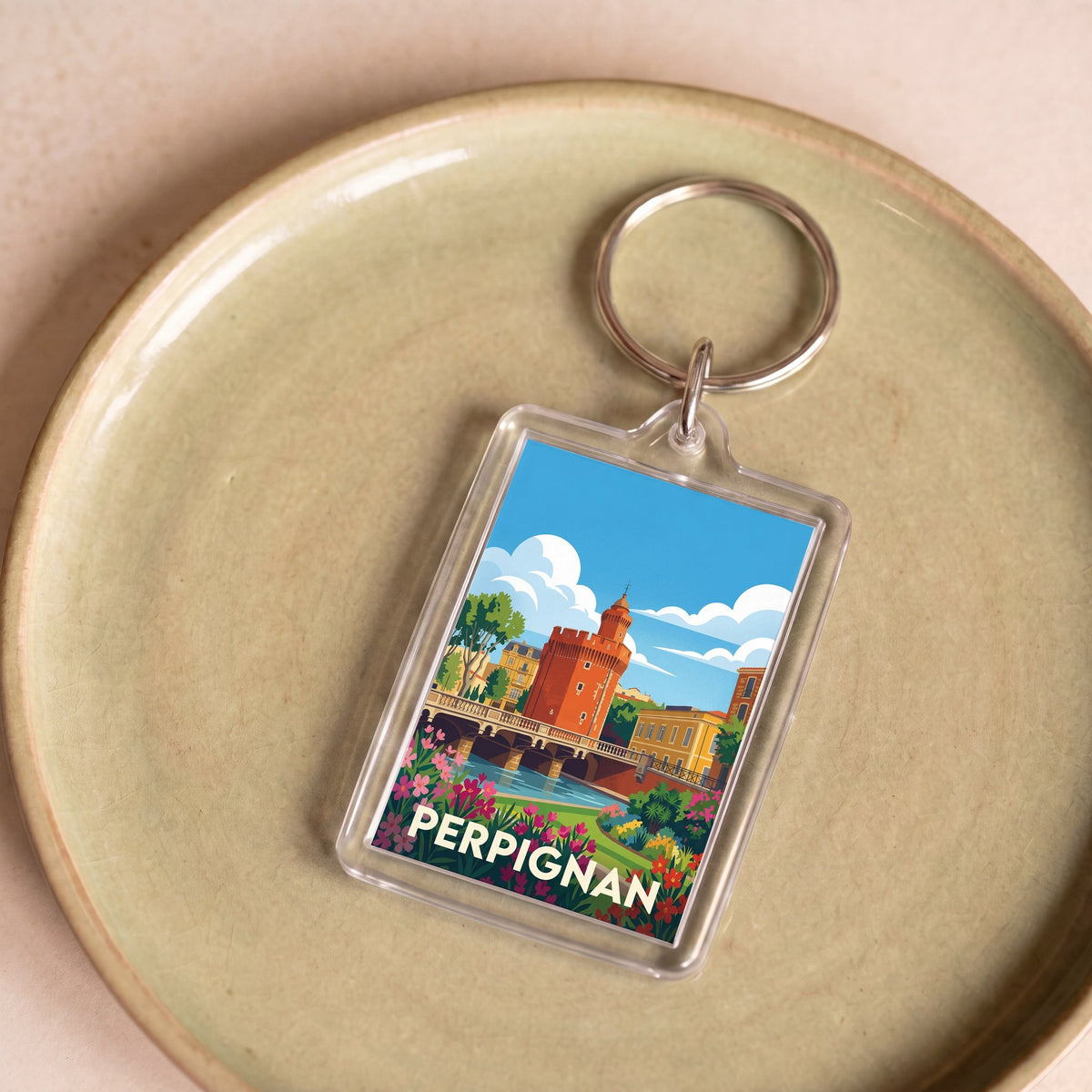 Porte-clés souvenir de la ville de Perpignan avec une illustration stylisée.