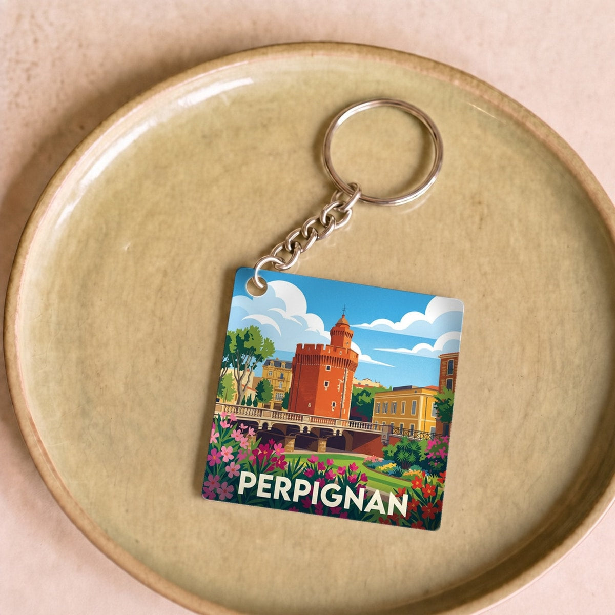 Porte-clés souvenir de la ville de Perpignan avec une illustration stylisée.