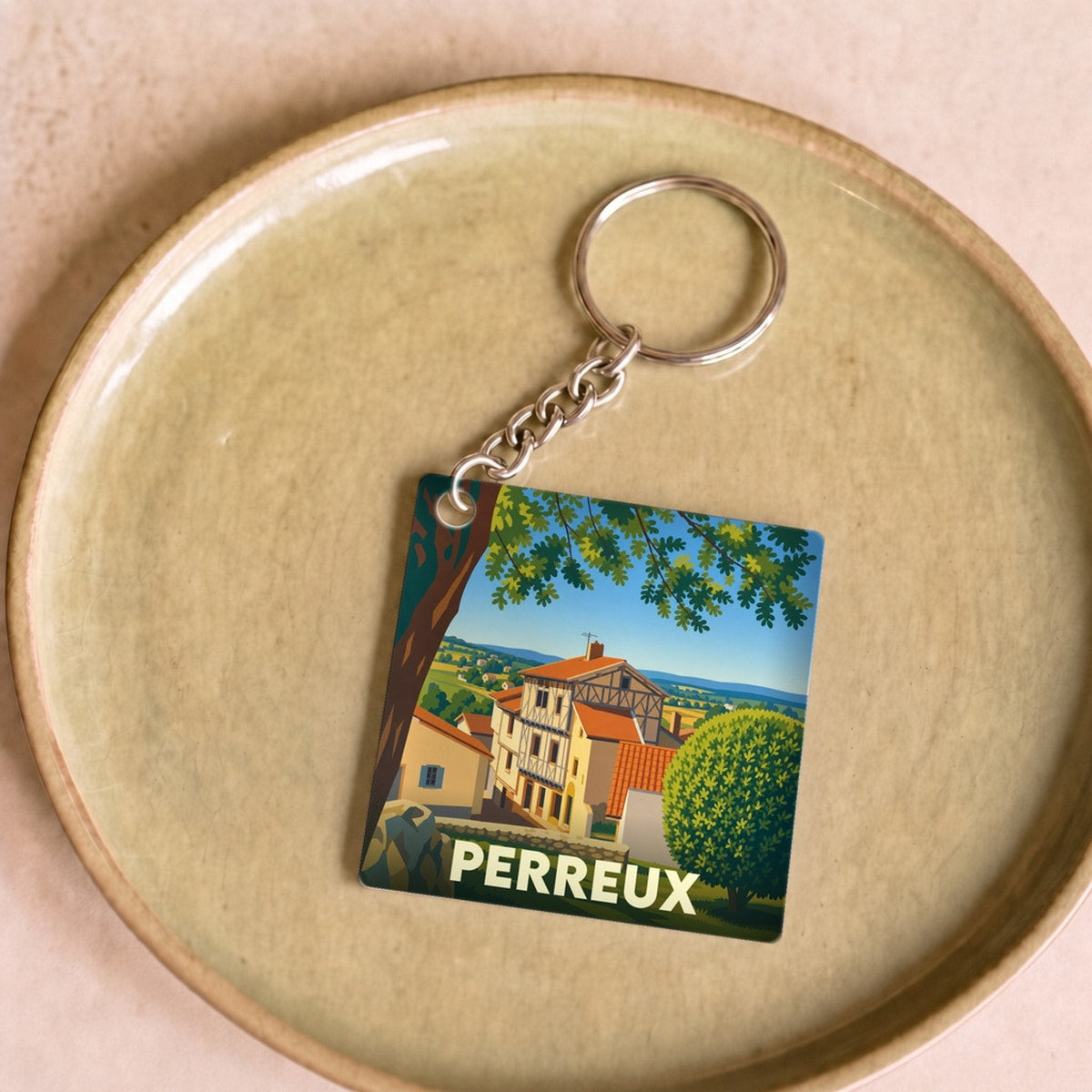Porte-clés souvenir de la ville de Perreux avec une illustration stylisée d'une maison à colombages.