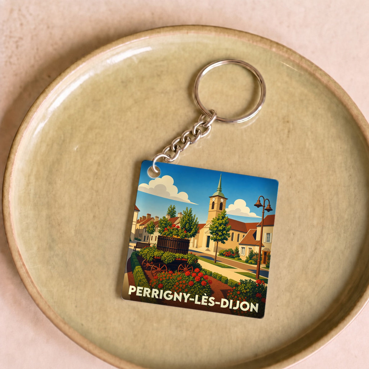 Porte-clés souvenir de la ville de Perrigny-lès-Dijon avec une illustration stylisée et colorée.
