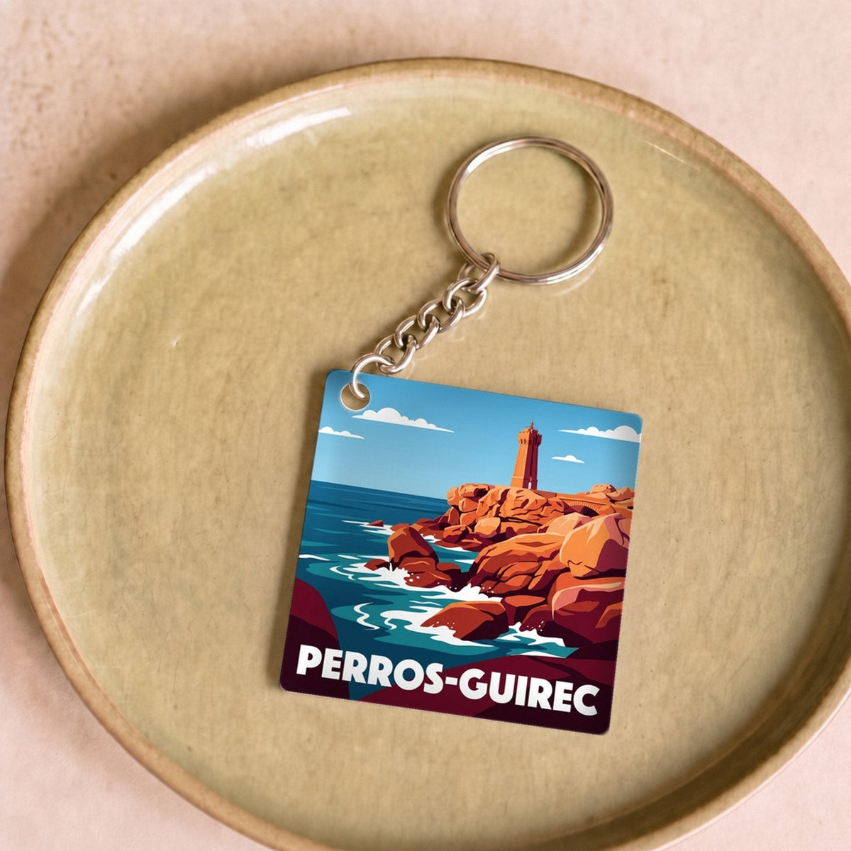 Porte-clés souvenir de la ville de Perros-Guirec avec une illustration stylisée.