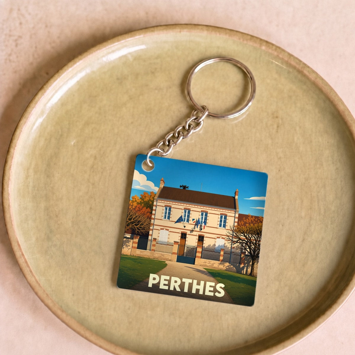 Porte-clés souvenir de la ville de Perthes avec une illustration stylisée.