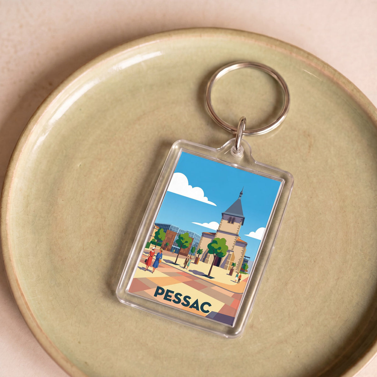 Porte-clés souvenir de la ville de Pessac avec une illustration graphique stylisée.