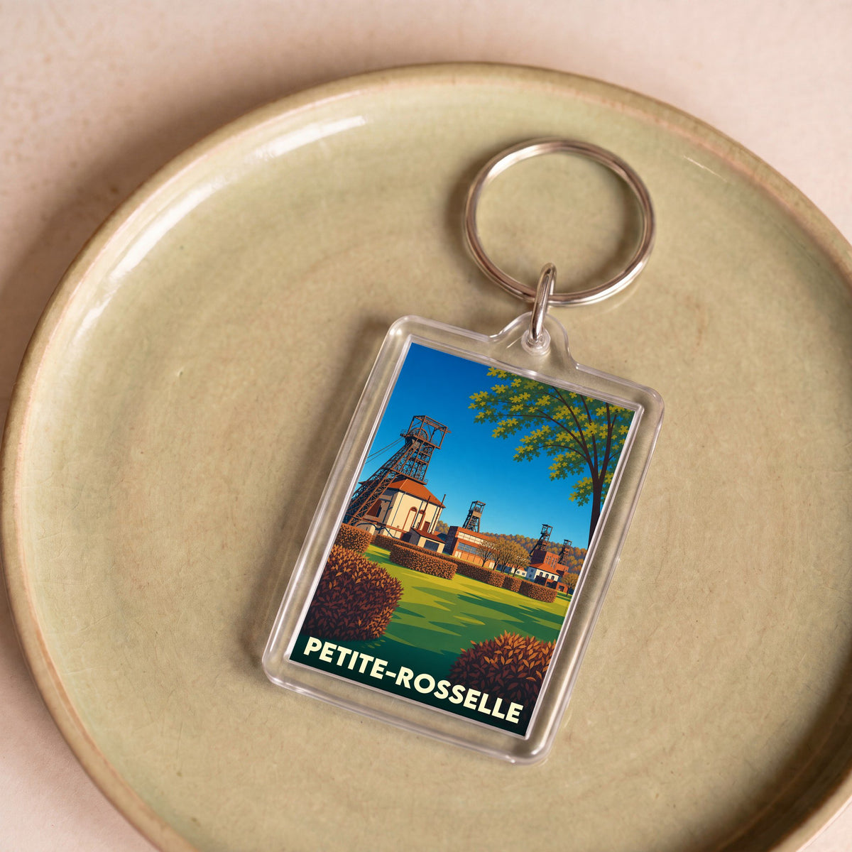 Porte-clés souvenir de la ville de Petite-Rosselle avec une illustration stylisée d'un ancien site minier.