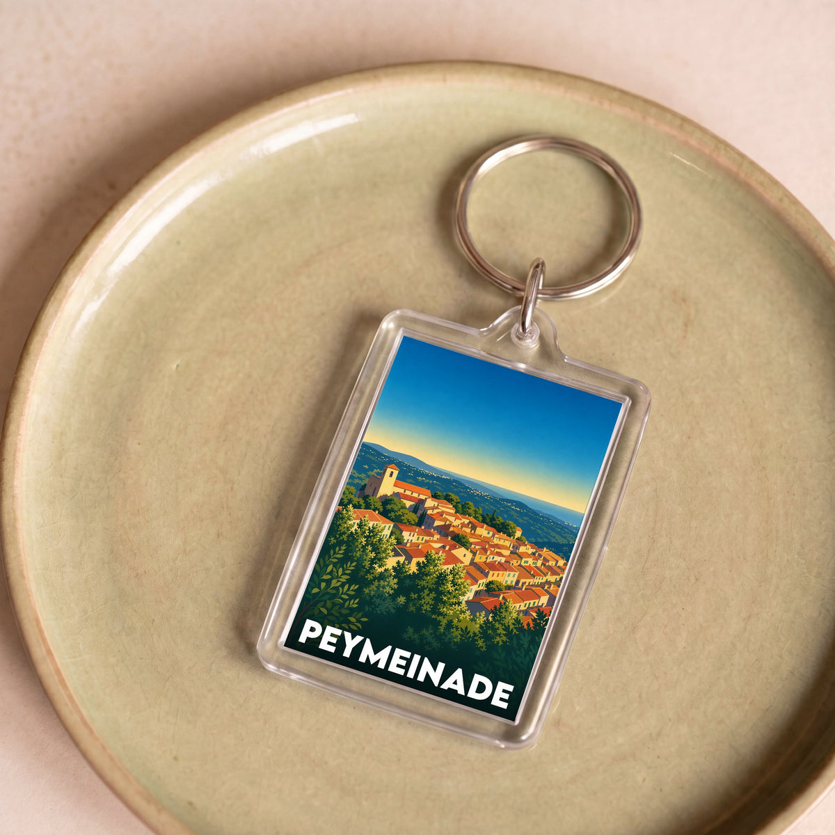 Porte-clés souvenir de la ville de Peymeinade avec une illustration stylisée.
