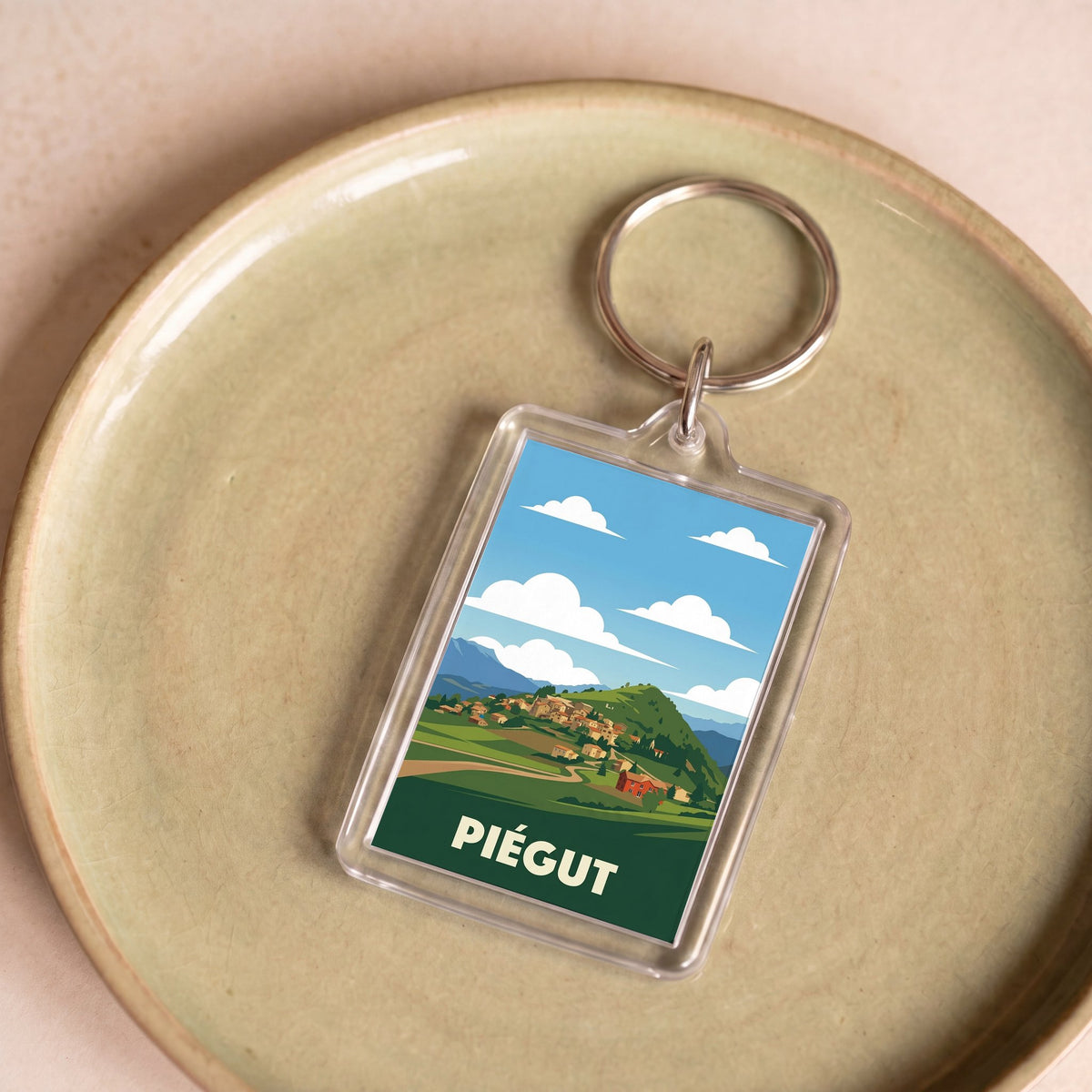 Porte-clés souvenir de la ville de Piégut orné d'une illustration stylisée.