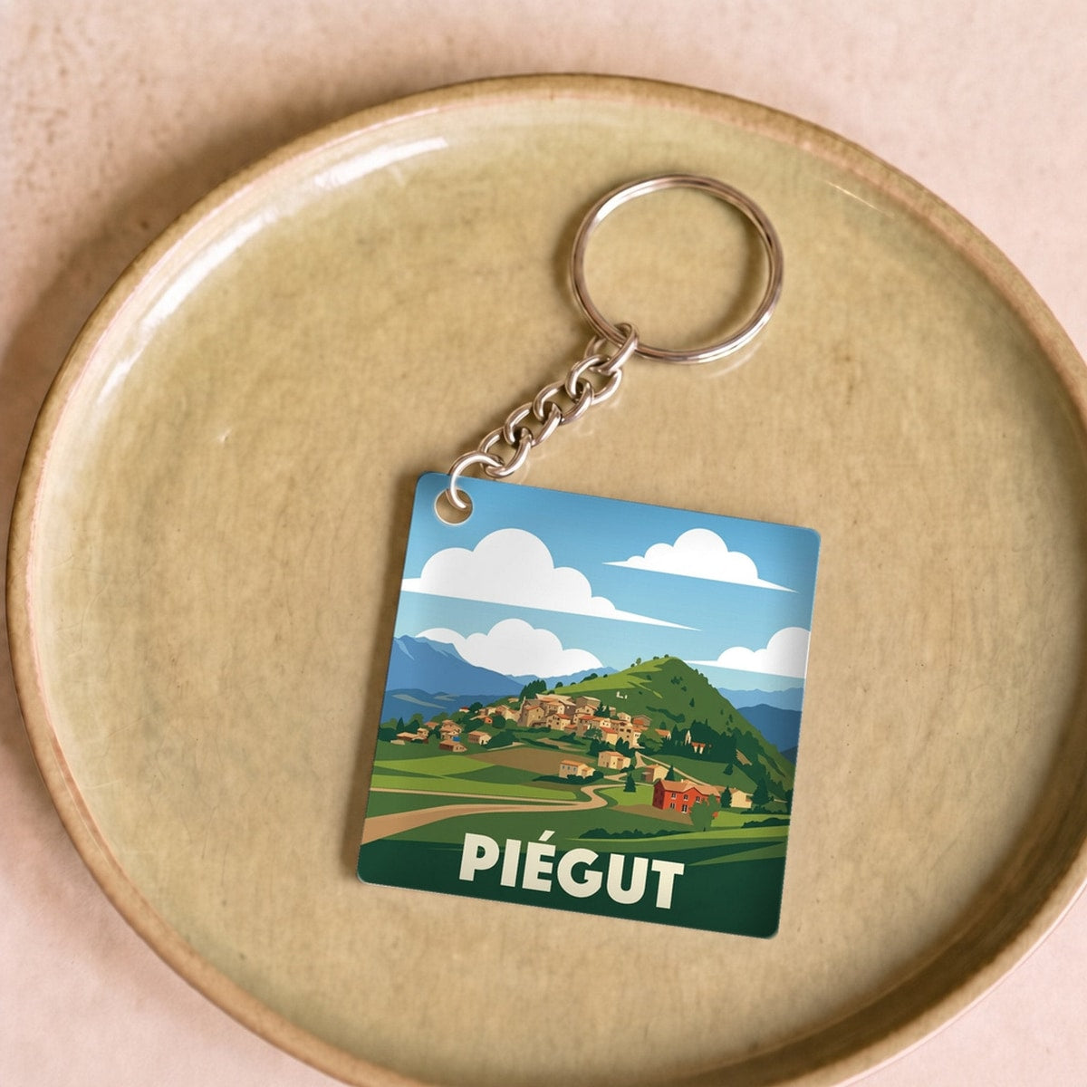 Porte-clés souvenir de la ville de Piégut orné d'une illustration stylisée.