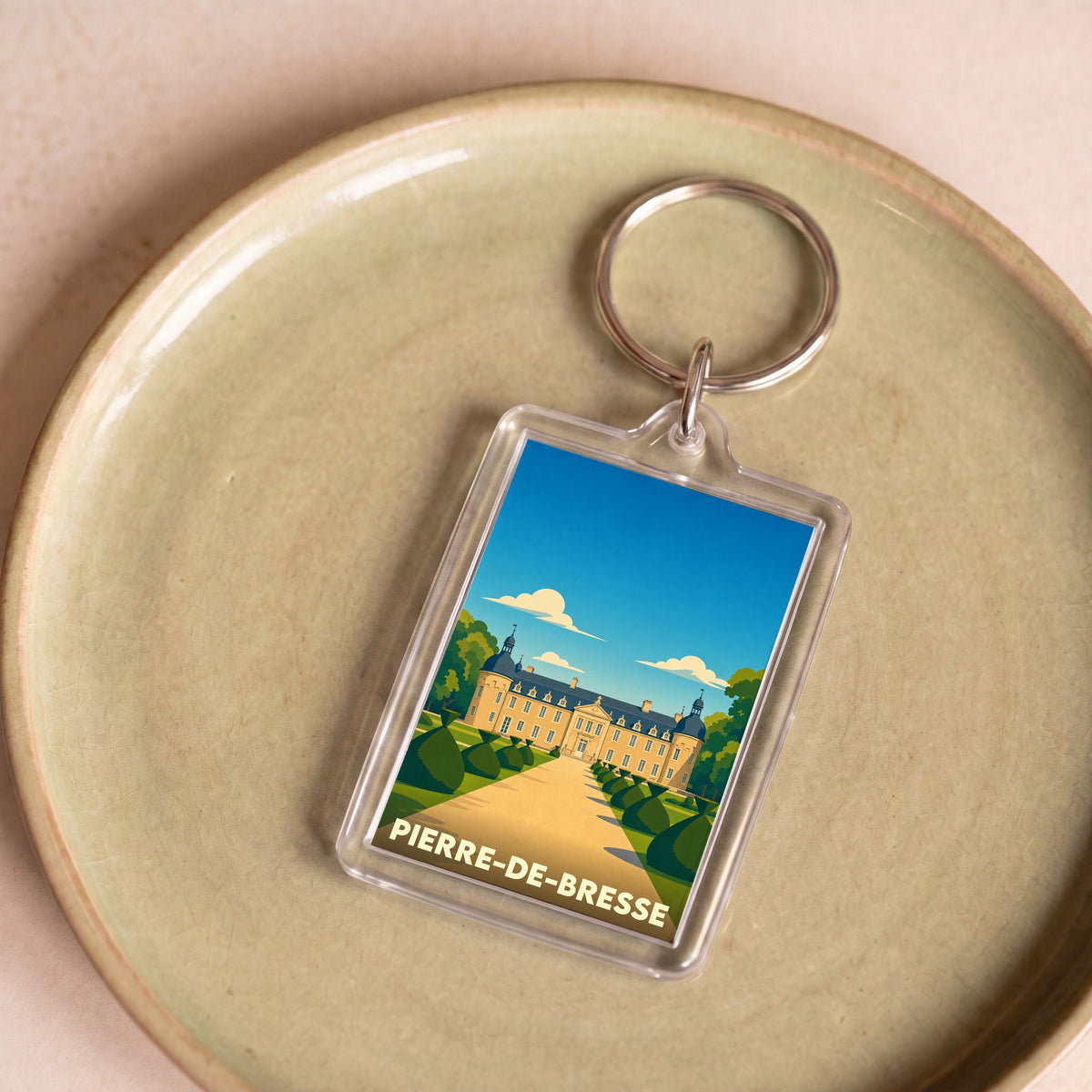Porte-clés souvenir de la ville de Pierre-de-Bresse avec une illustration stylisée du château local.