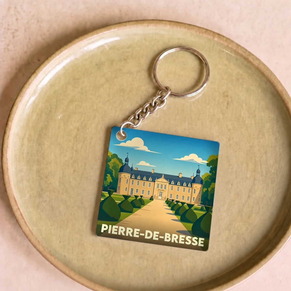 Porte-clés souvenir de la ville de Pierre-de-Bresse avec une illustration stylisée du château local.