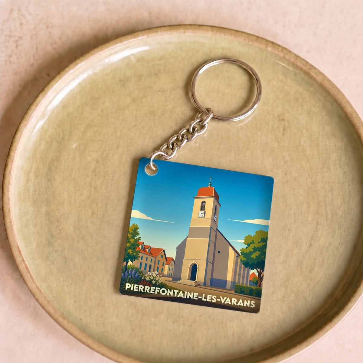 Porte-clés souvenir de la ville de Pierrefontaine-les-Varans avec une illustration stylisée de son église.