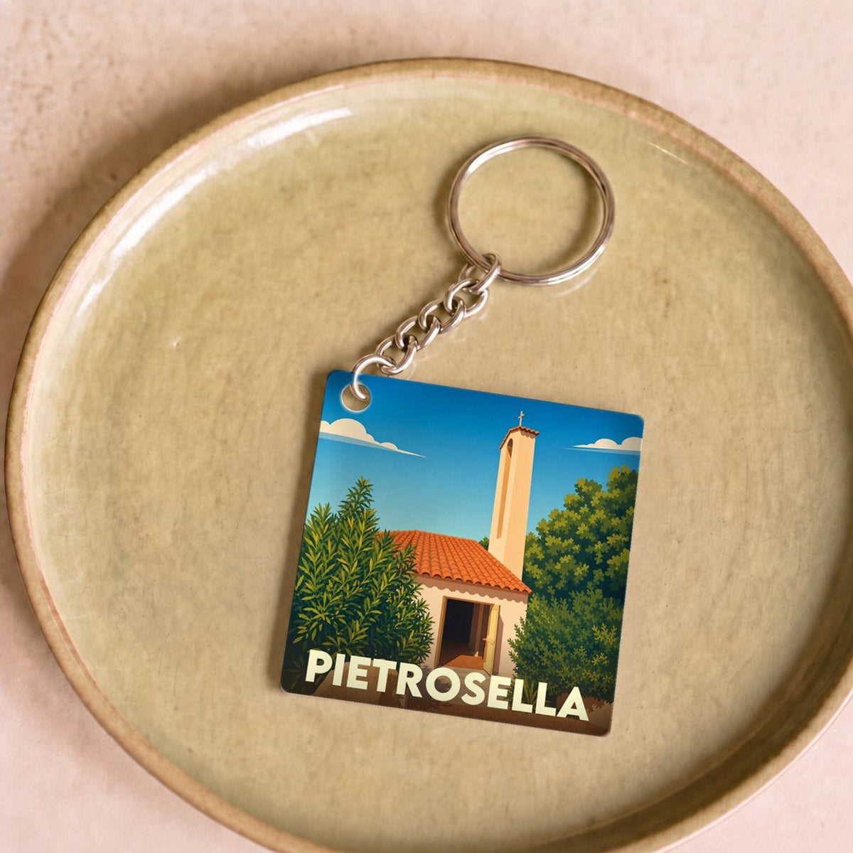 Porte-clés souvenir de la ville de Pietrosella avec une illustration stylisée.