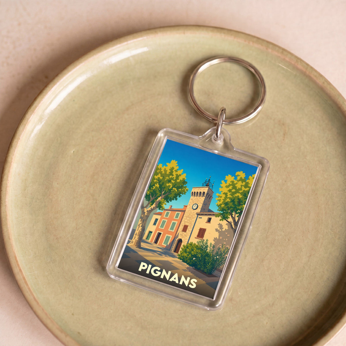 Porte-clés souvenir de la ville de Pignans avec une illustration stylisée.