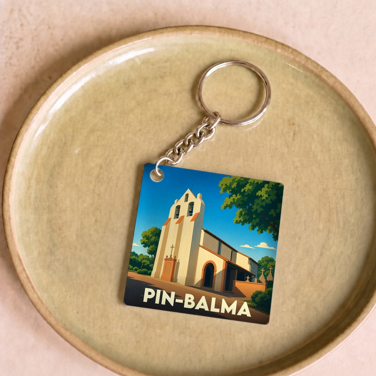 Porte-clés souvenir de la ville de Pin-Balma avec une illustration stylisée de son église.