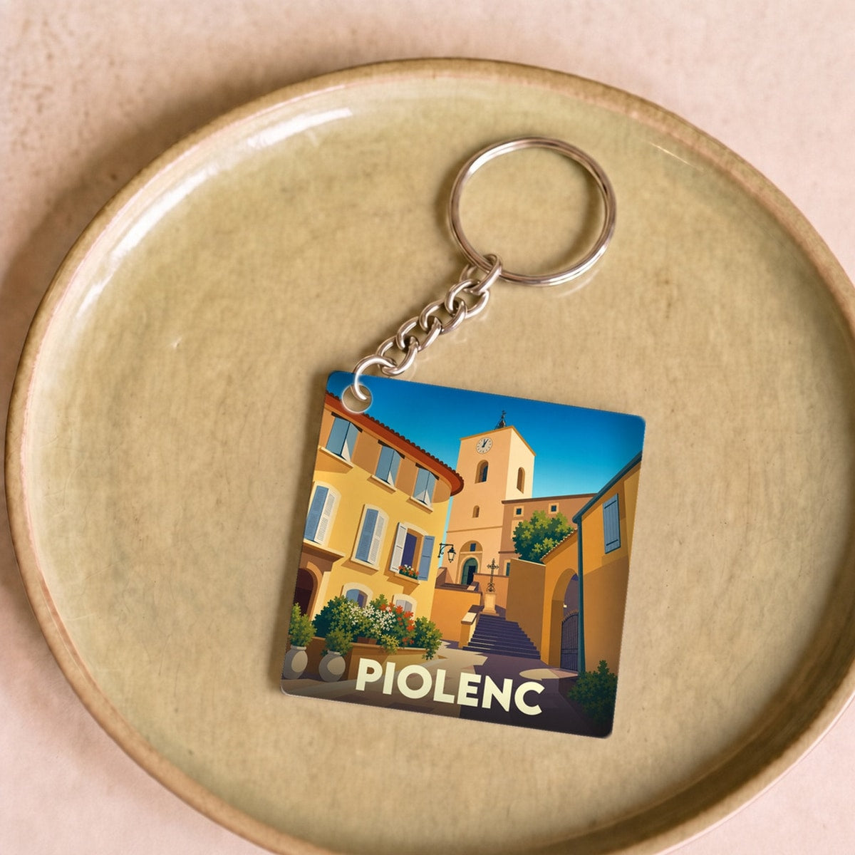 Porte-clés souvenir de la ville de Piolenc avec une illustration stylisée.