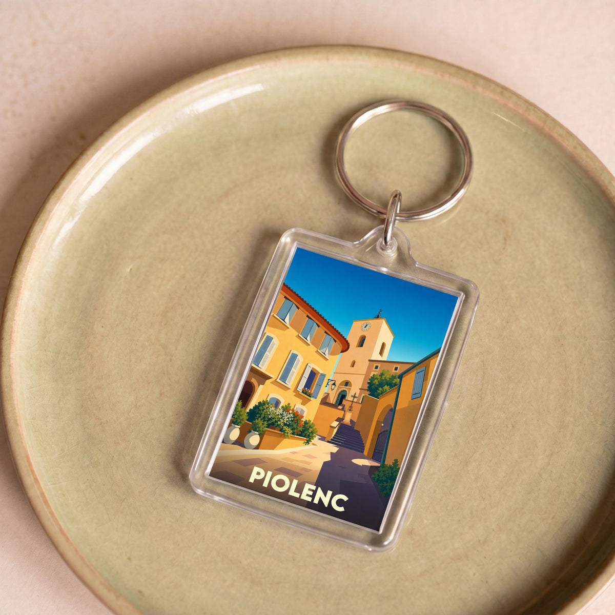 Porte-clés souvenir de la ville de Piolenc avec une illustration stylisée.