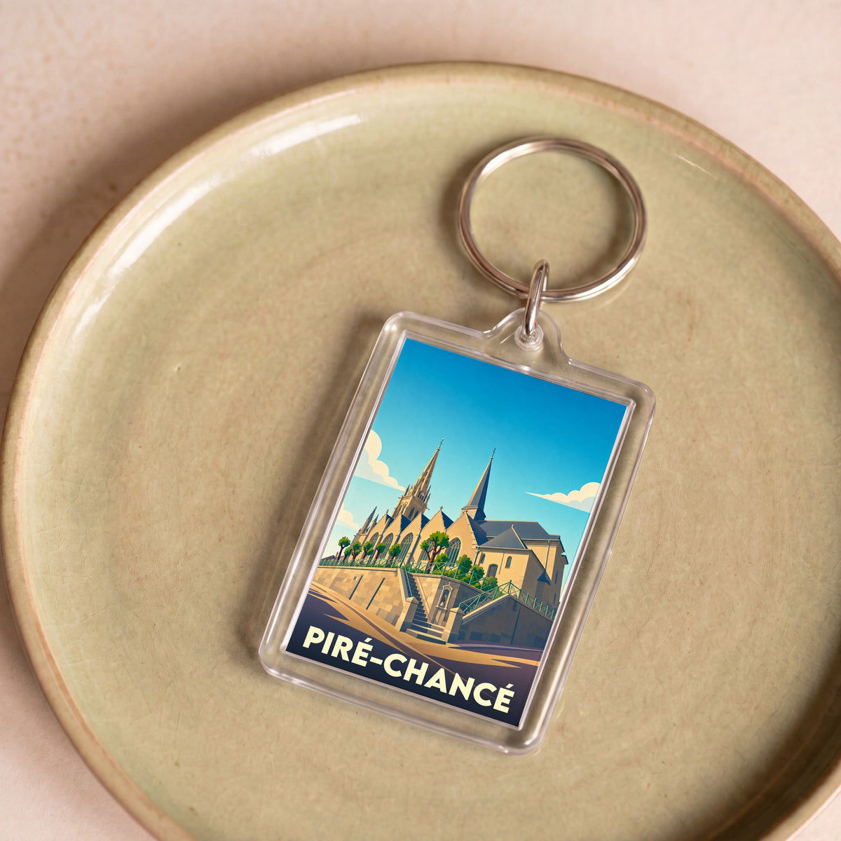 Porte-clés souvenir de la ville de Piré-Chancé avec une illustration stylisée de son église.