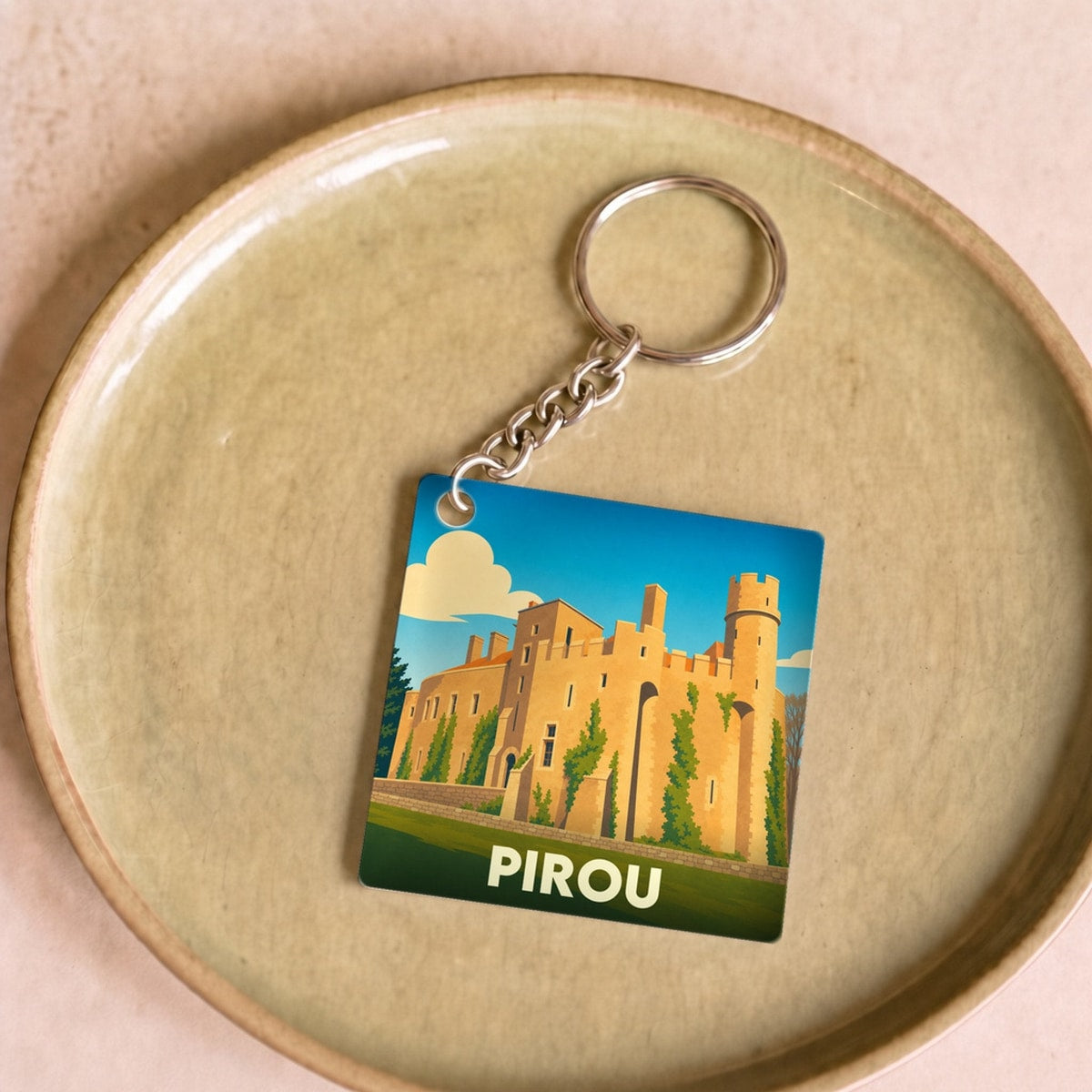 Porte-clés souvenir de la ville de Pirou avec une illustration stylisée de son château.