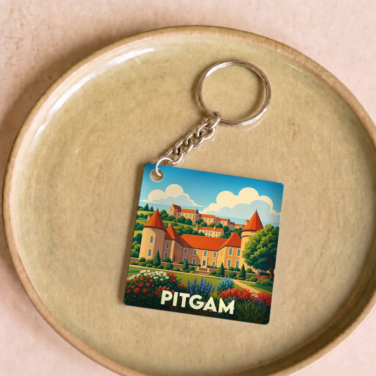 Porte-clés souvenir de la ville de Pitgam avec une illustration stylisée.