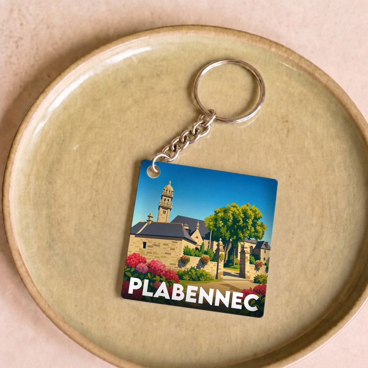 Porte-clés souvenir de la ville de Plabennec avec une illustration stylisée.