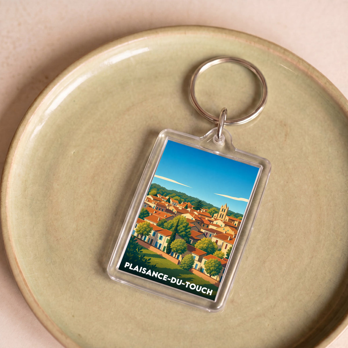 Porte-clés souvenir de la ville de Plaisance-du-Touch avec une illustration stylisée.