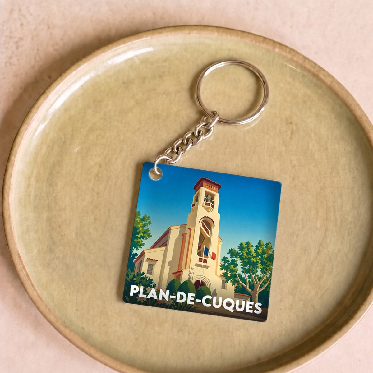 Porte-clés souvenir de la ville de Plan-de-Cuques avec une illustration stylisée.