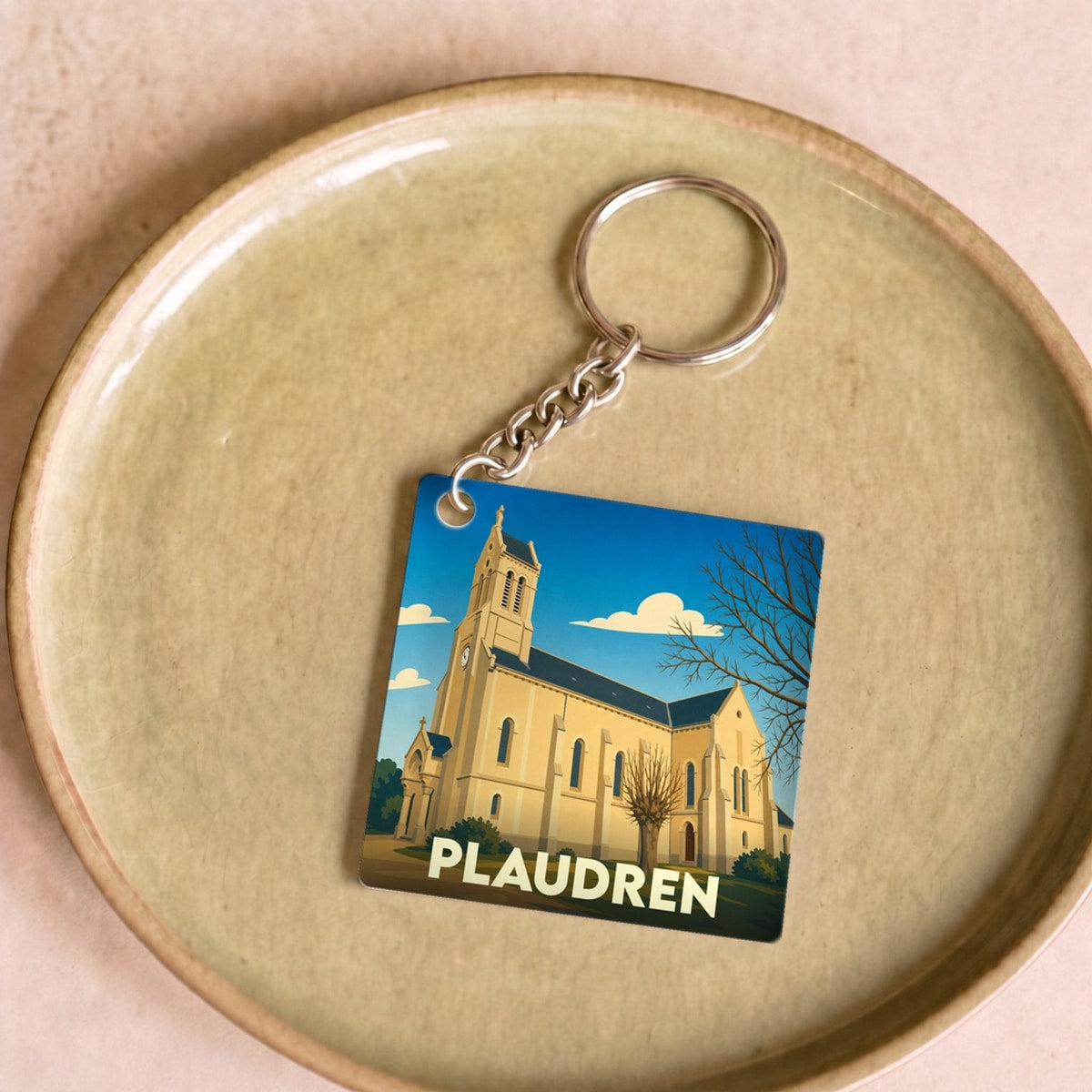 Porte-clés souvenir de la ville de Plaudren avec une illustration stylisée d'une église.