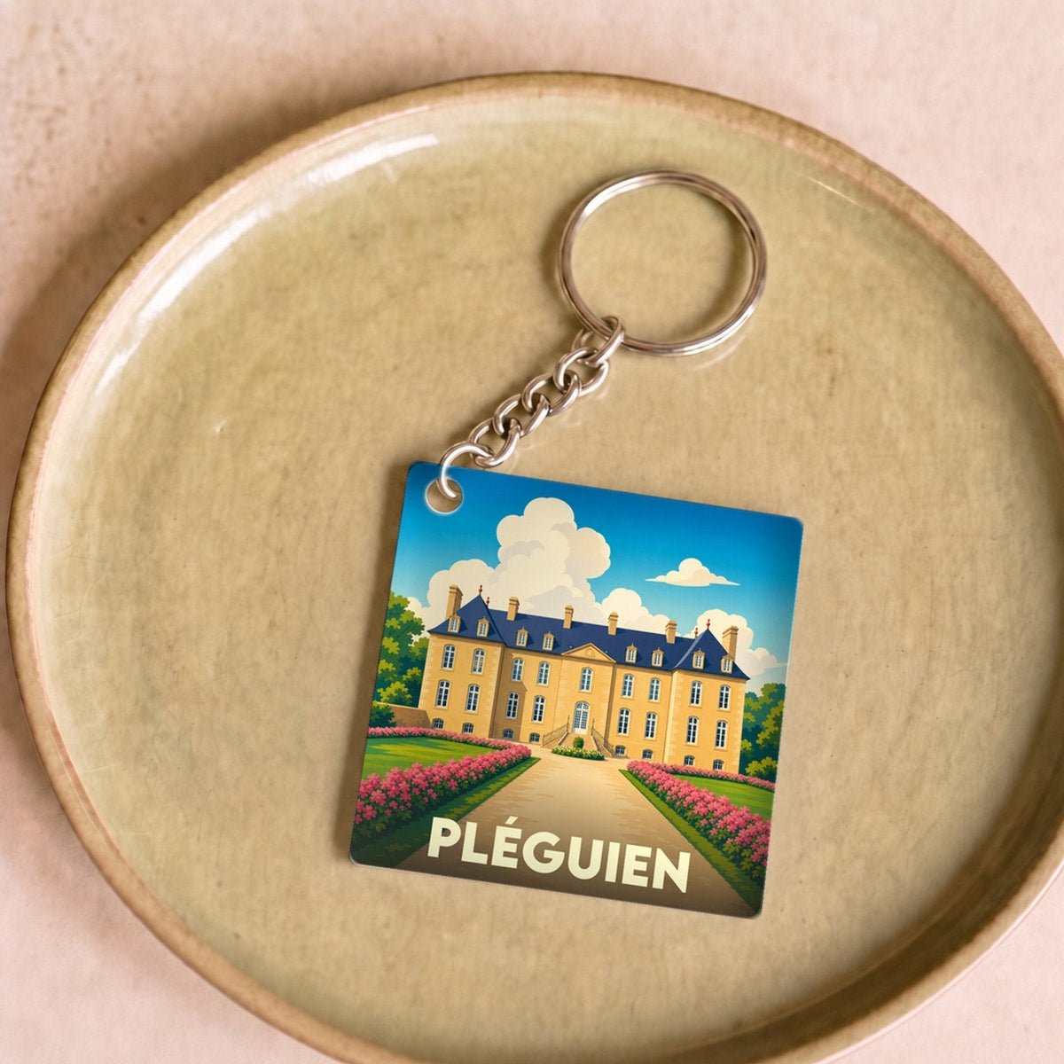 Porte-clés souvenir de la ville de Pléguien avec une illustration stylisée d'un château.