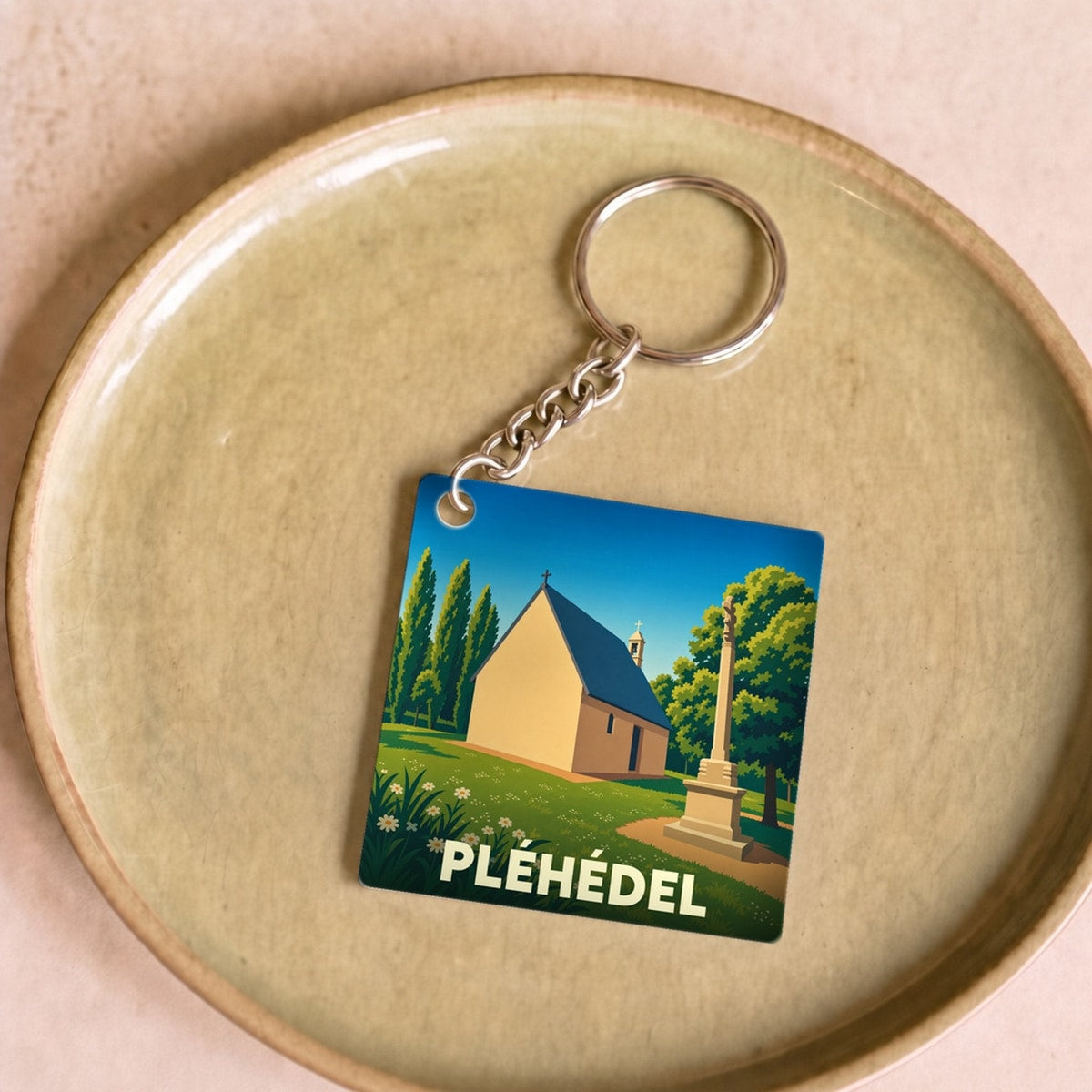 Porte-clés souvenir de la ville de Pléhédel avec une illustration stylisée.